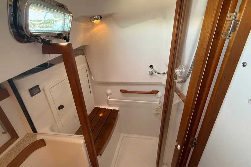 Slide: The Image of 2009 Sabre 386 yacht bathroom with wooden accents and a porthole window. - 49