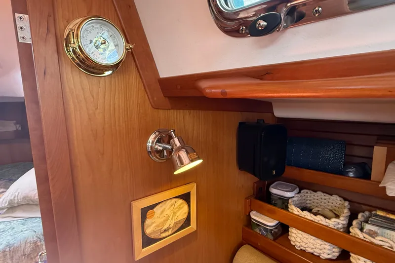 Slide: The Image of Interior of 2009 Sabre 386 sailboat with wooden paneling, barometer, and storage shelves. - 21
