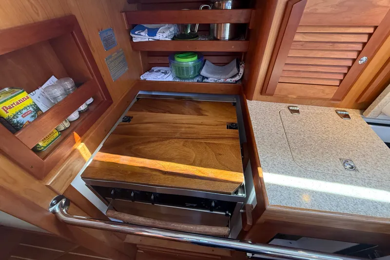 Slide: The Image of Wooden galley kitchen in 2009 Sabre 386 sailboat with stove and storage shelves. - 29