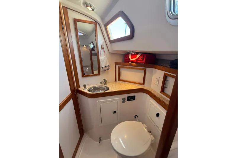 Slide: The Image of Compact boat bathroom with sink, mirror, and toilet in 2009 Sabre 386 yacht. - 51