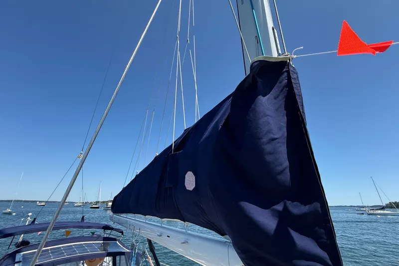 Slide: The Image of Sailboat Sabre 386 (2009) with covered sail and red pennant on a sunny day. - 74