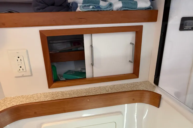 Slide: The Image of Cabinet with sliding doors in 2009 Sabre 386 boat interior, featuring wood trim and countertop. - 55