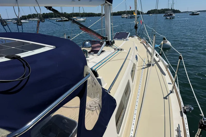 Slide: The Image of 2009 Sabre 386 sailboat on calm water, featuring a sleek deck and blue canopy. - 100