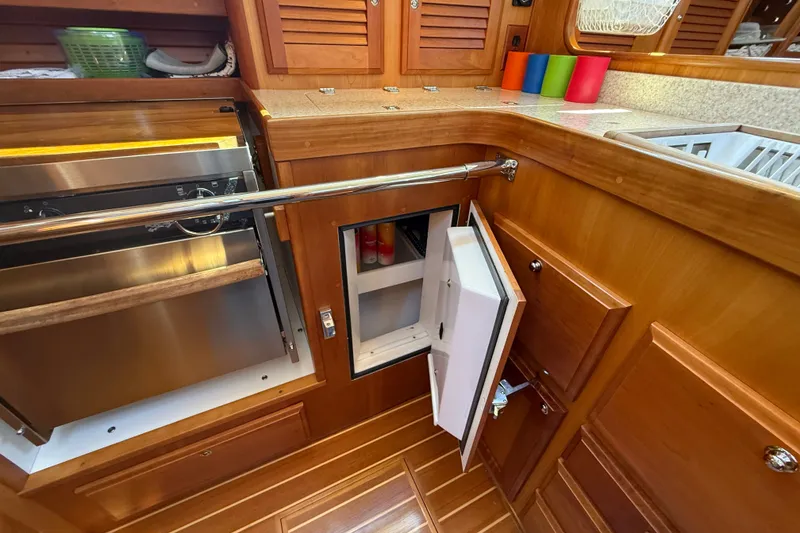 Slide: The Image of 2009 Sabre 386 yacht kitchen with wooden cabinetry, open fridge, and stainless steel oven. - 28