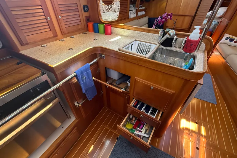 Slide: The Image of Luxurious 2009 Sabre 386 yacht kitchen with wooden cabinetry, sink, and organized storage. - 26