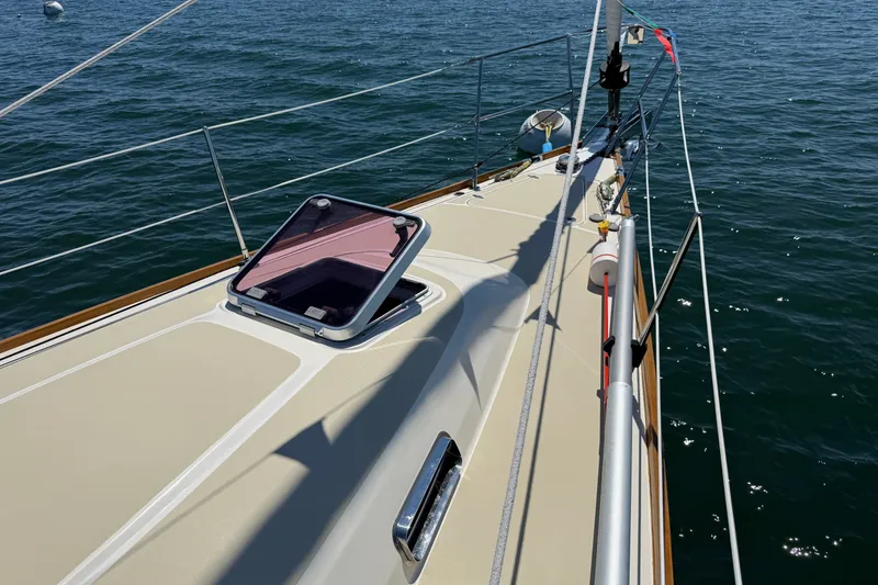 Slide: The Image of 2009 Sabre 386 sailboat deck with open hatch, sailing on calm waters. - 69