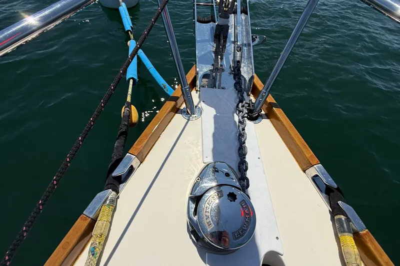 Slide: The Image of Bow of 2009 Sabre 386 sailboat with anchor chain and winch on calm water. - 65