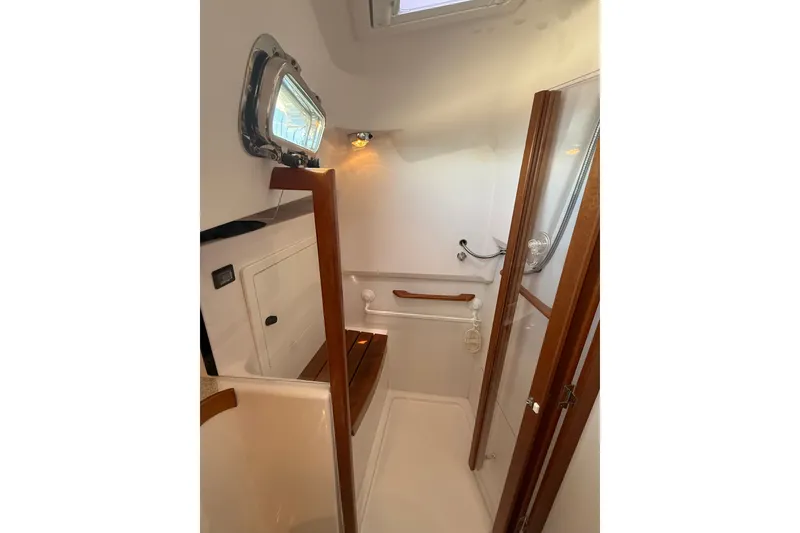 Slide: The Image of 2009 Sabre 386 yacht interior with wooden accents and porthole window. - 53