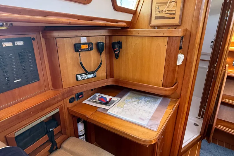 Slide: The Image of Navigation station in 2009 Sabre 386 sailboat with communication equipment and nautical charts. - 16