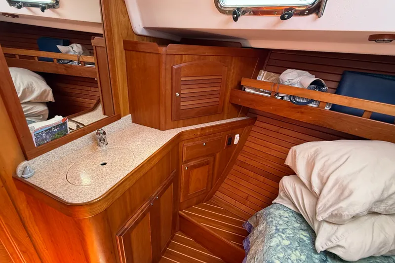 Slide: The Image of 2009 Sabre 386 yacht interior with wooden cabinetry, sink, and cozy bedding. - 41