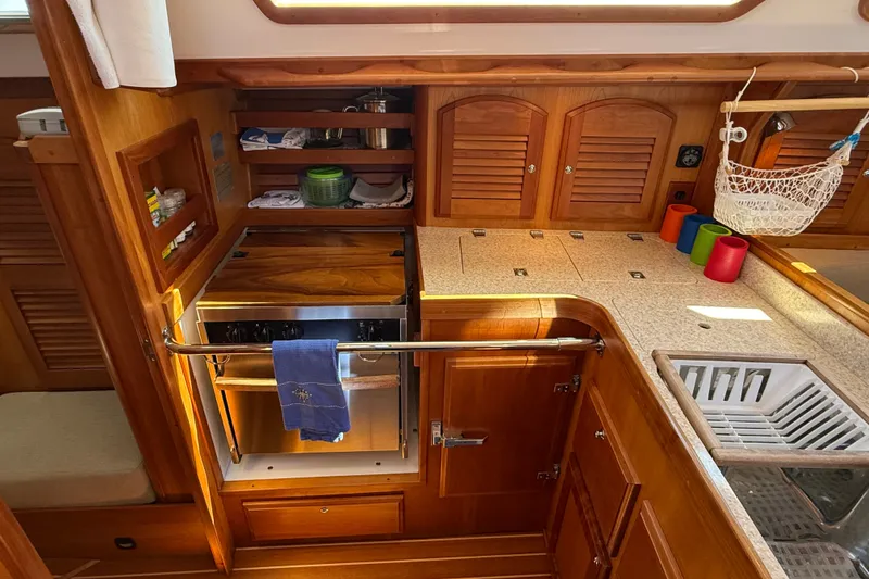 Slide: The Image of Wooden yacht galley with stove, storage, and countertop in a 2009 Sabre 386 sailboat. - 35