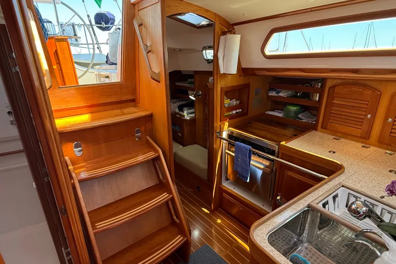 Slide: The Image of Interior of 2009 Sabre 386 yacht with wooden cabinetry and compact kitchen area. - 24