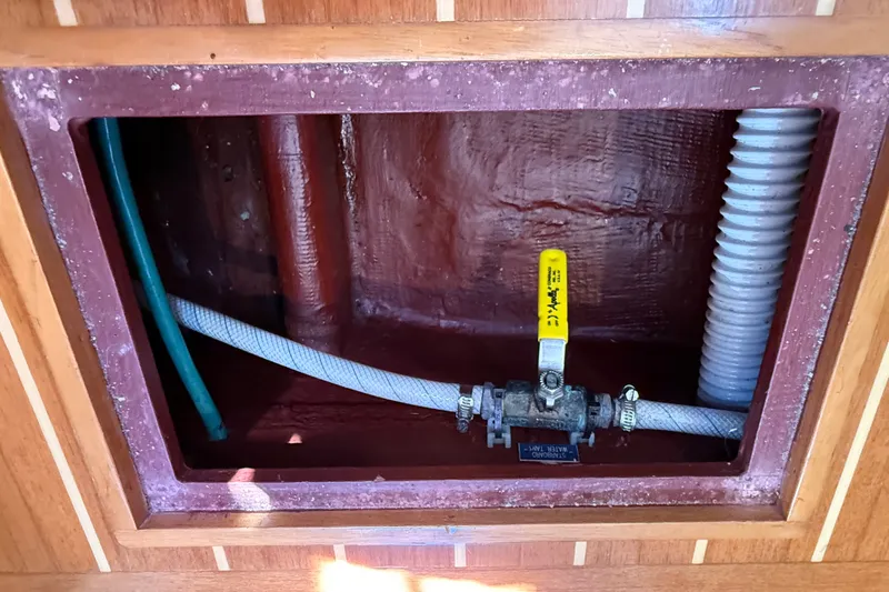 Slide: The Image of Access panel with plumbing pipes and valve in 2009 Sabre 386 boat. - 104