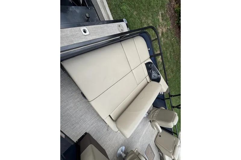 Slide: The Image of 2025 Regency 250DL3 boat interior with beige seating and cup holders. - 22