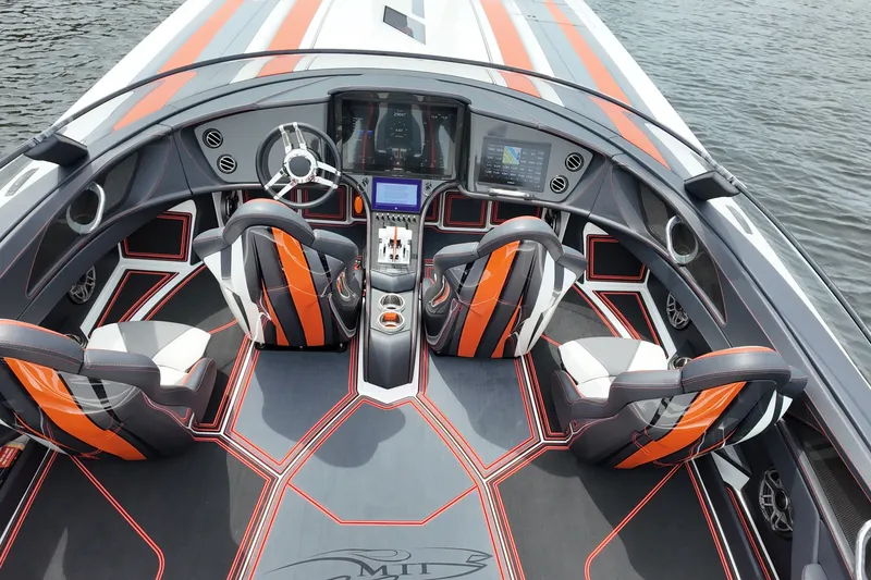 Slide: The Image of 2024 MTI 440X boat interior with modern dashboard, sleek design, and vibrant seating on water. - 13
