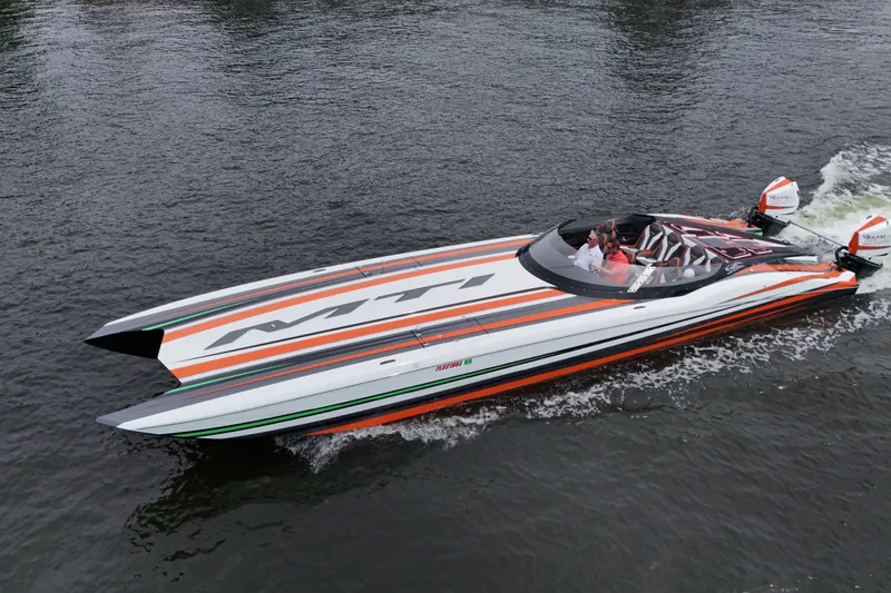 Slide: The Image of 2024 MTI 440X powerboat with vibrant stripes cruising on water. - 7