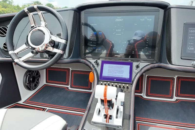 Slide: The Image of 2024 MTI 440X boat dashboard with advanced navigation screens and sleek steering wheel design. - 11