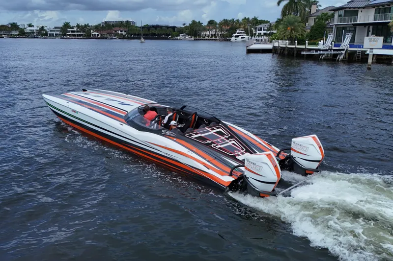 Slide: The Image of 2024 MTI 440X speedboat with vibrant stripes cruising on a scenic waterway. - 9