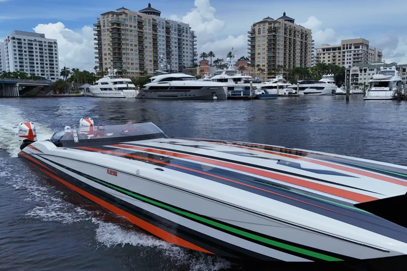 Slide: The Image of 2024 MTI 440X powerboat cruising near luxury yachts and waterfront buildings. - 5