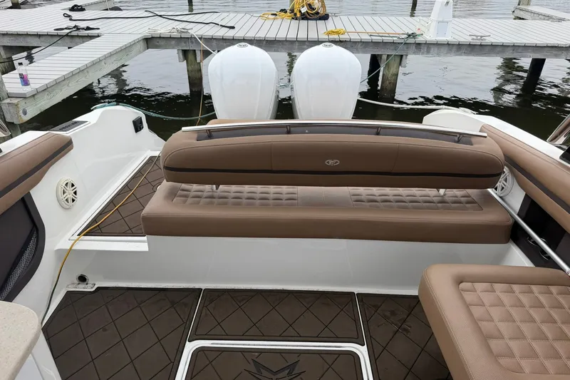 Slide: The Image of 2020 Cobalt 30SC boat interior with brown seating and docked at a marina. - 21