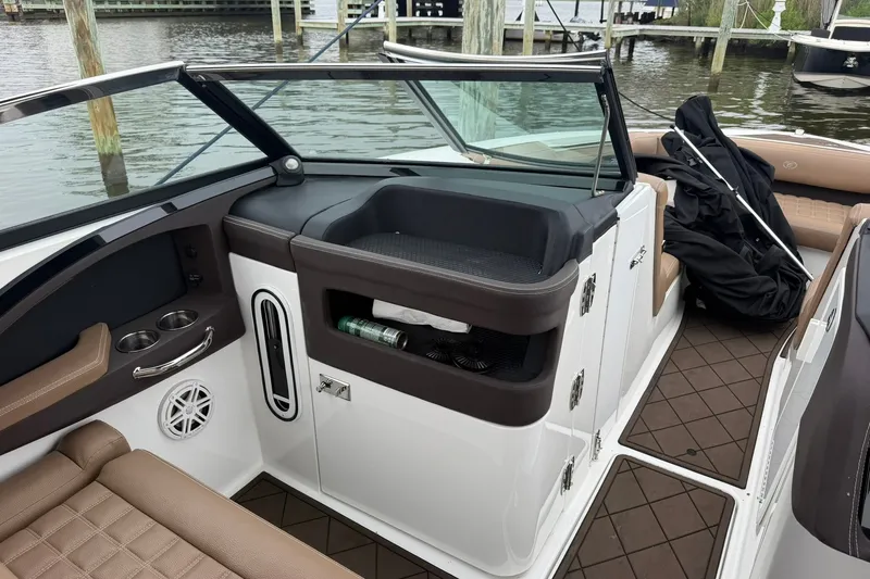 Slide: The Image of 2020 Cobalt 30SC boat interior with seating, storage, and cup holders by the dock. - 16