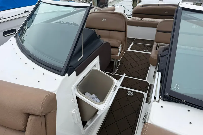 Slide: The Image of 2020 Cobalt 30SC boat interior with brown seating and open storage compartment. - 11