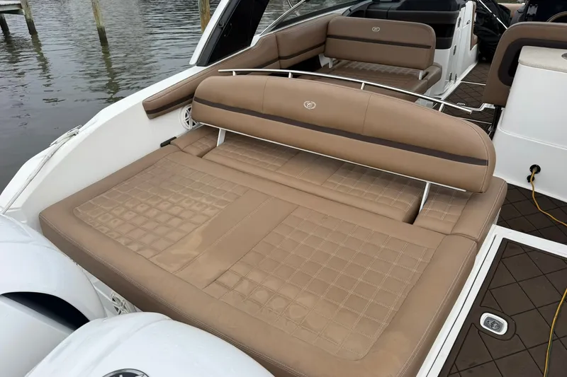 Slide: The Image of 2020 Cobalt 30SC boat with tan leather seating, docked by the water. - 22