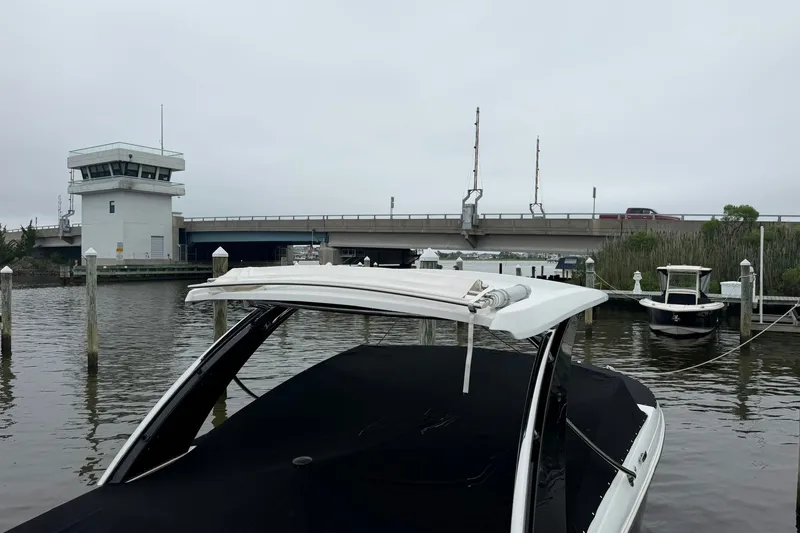Slide: The Image of 2020 Cobalt 30SC boat docked near a bridge and control tower on a cloudy day. - 4