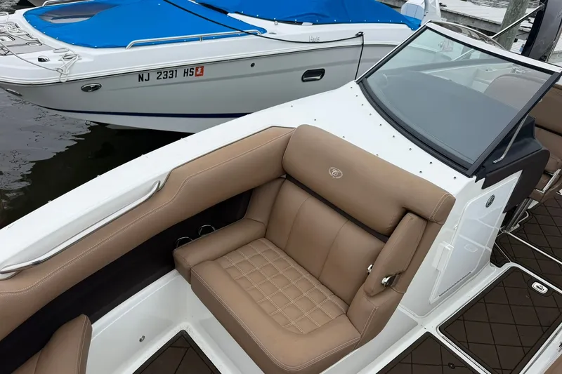Slide: The Image of 2020 Cobalt 30SC boat with tan seating and sleek design, docked beside another boat. - 7