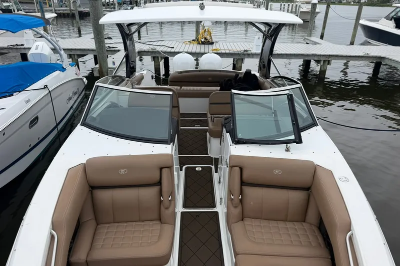 Slide: The Image of 2020 Cobalt 30SC boat with tan seating, docked at a marina. - 9