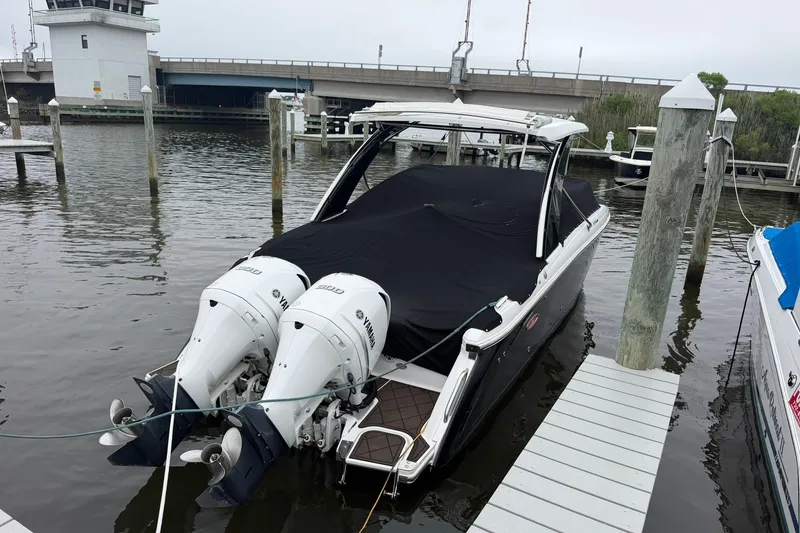 Slide: The Image of 2020 Cobalt 30SC boat docked with twin Yamaha outboard engines, covered and moored. - 3