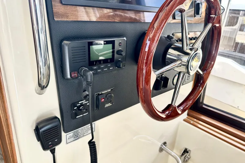 Slide: The Image of 2026 Ranger Tugs R-31 CB helm with wooden steering wheel and Garmin controls. - 22