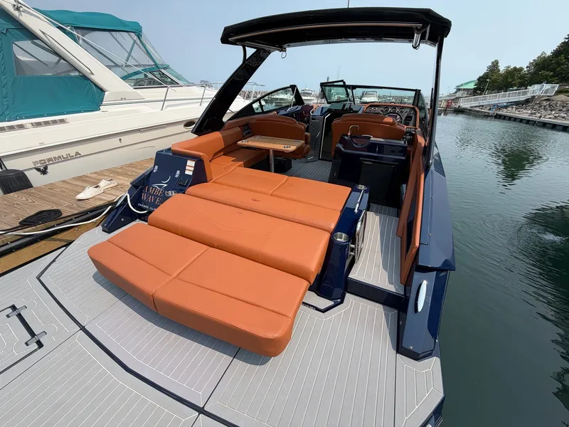 Slide: The Image of The image shows a luxurious 2022 Cruisers Yachts 338 CX South Beach Bow Rider. It features orange upholstery and a sleek design, docked at a marina. - 3