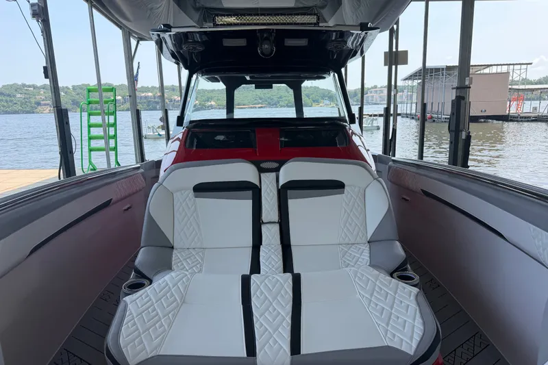 Slide: The Image of 2027 Nor-Tech 42 Eleven boat interior with white seating, docked by a scenic lake. - 62