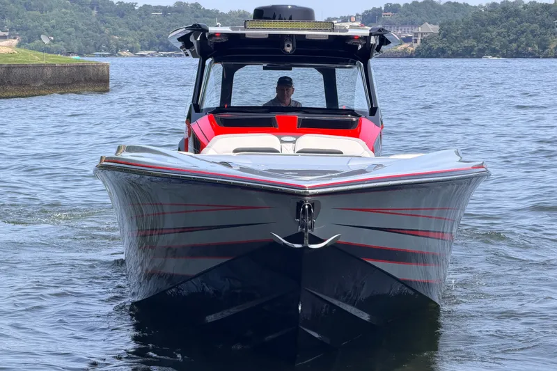 Slide: The Image of 2027 Nor-Tech 42 Eleven boat on water, front view with sleek design and red accents. - 3
