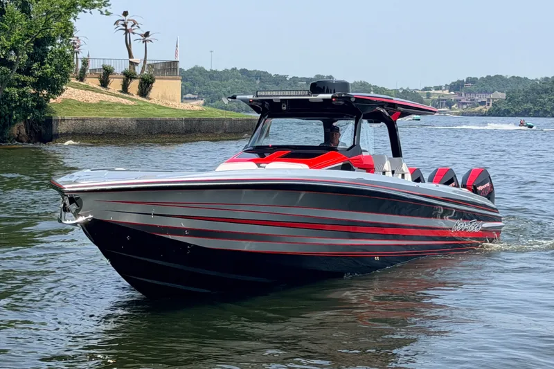Slide: The Image of 2027 Nor-Tech 42 Eleven boat with sleek red and black design on a calm lake. - 9