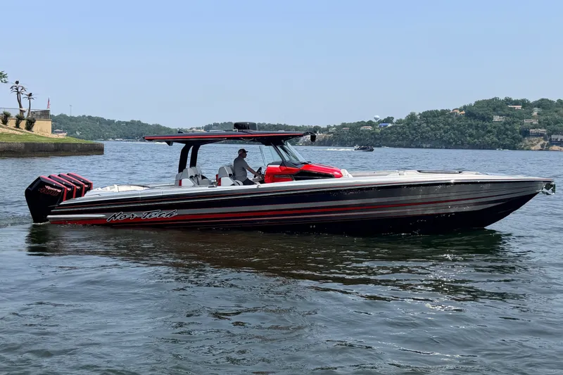 Slide: The Image of 2027 Nor-Tech 42 Eleven boat on a scenic lake with lush green hills. - 13