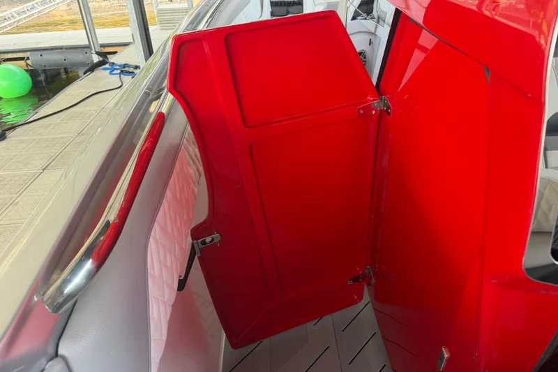 Slide: The Image of Red interior door of 2027 Nor-Tech 42 Eleven boat, open near dock. - 55