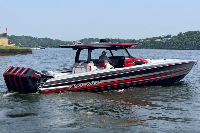 Slide: The Image of 2027 Nor-Tech 42 Eleven boat with triple engines cruising on a scenic lake. - 24