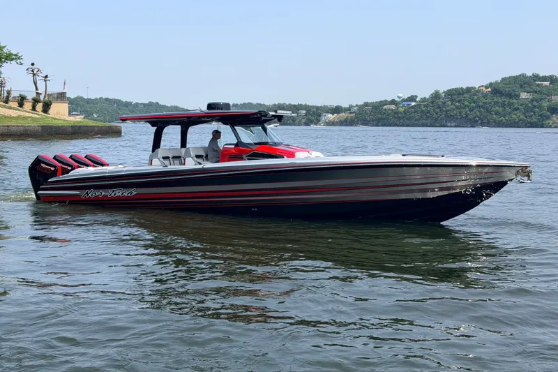 Slide: The Image of 2027 Nor-Tech 42 Eleven boat on a calm lake, featuring sleek design and powerful engines. - 16