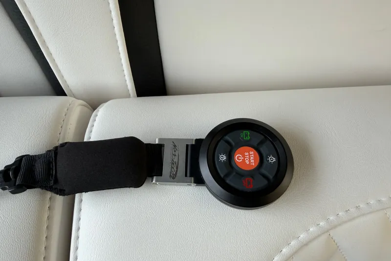 Slide: The Image of Control panel on Nor-Tech 42 Eleven 2027 boat, featuring start-stop button on white upholstery. - 59