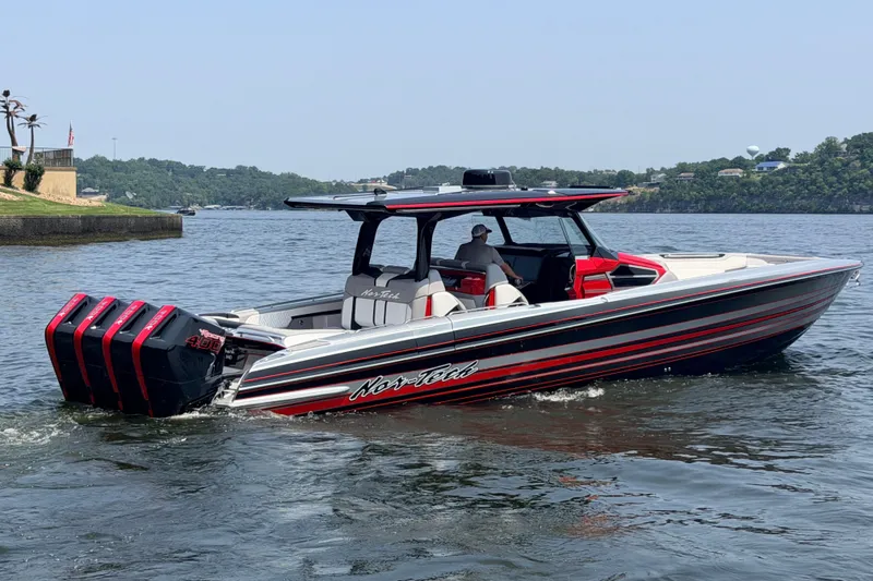 Slide: The Image of 2027 Nor-Tech 42 Eleven boat cruising on a lake with triple outboard engines. - 23
