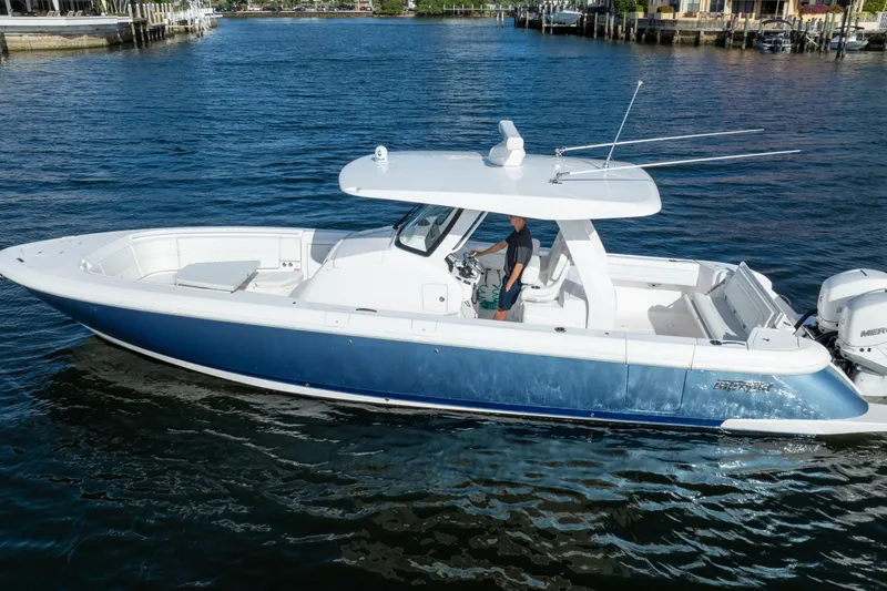 The Image of 2022 Intrepid 345 Nomad SE boat cruising on a calm blue waterway. - 0