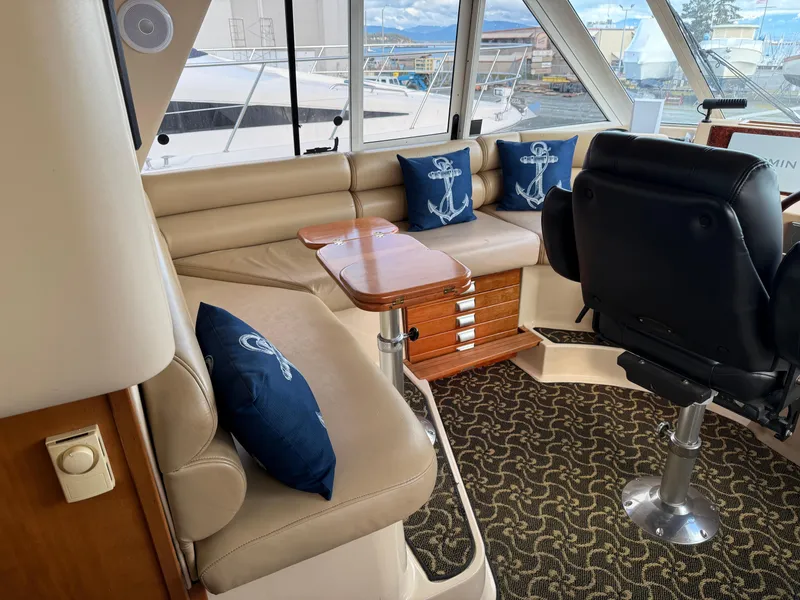 Slide: The Image of Interior of 2003 Meridian 490 Pilothouse with seating, nautical pillows, and helm chair. - 28