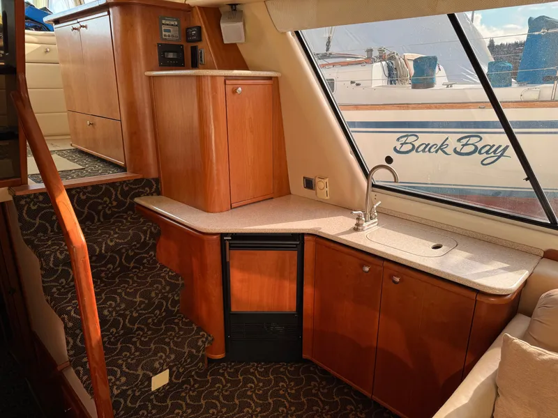 Slide: The Image of Interior of 2003 Meridian 490 Pilothouse yacht with wood cabinetry and compact kitchenette. - 16