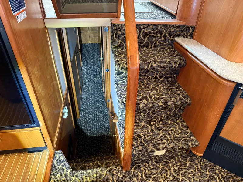 Slide: The Image of Interior stairs of 2003 Meridian 490 Pilothouse with patterned carpet and wooden finish. - 53