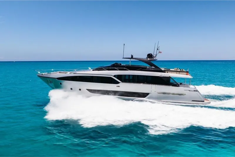 Slide: The Image of Luxury 2022 Riva 90' Argo yacht cruising on clear blue ocean waters. - 1