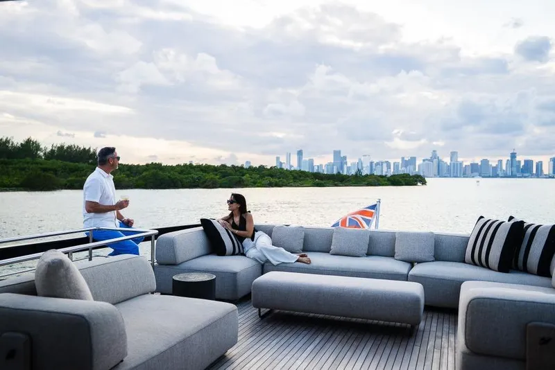 Slide: The Image of Luxury Riva 90' Argo yacht with people relaxing, city skyline in background, 2022 model. - 39