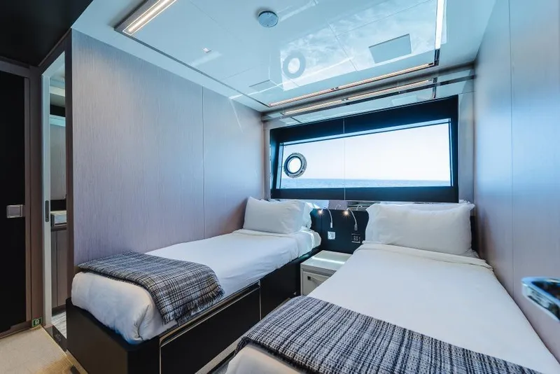 Slide: The Image of Luxurious twin cabin interior on 2022 Riva 90' Argo yacht, featuring modern design and ocean view. - 26