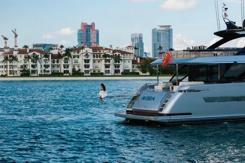 Slide: The Image of Luxury Riva 90' Argo yacht on water, city skyline in background, 2022 model. - 6